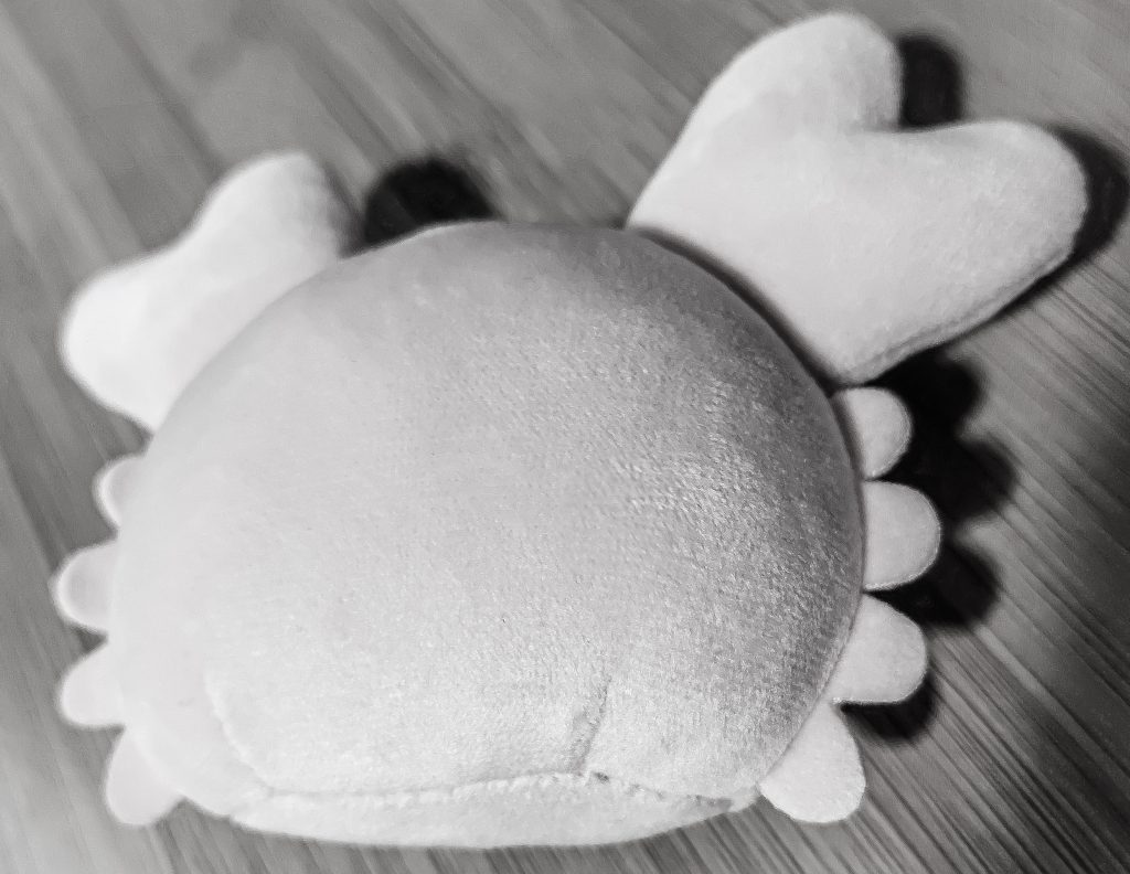カニのぬいぐるみが灰色になりうつぶせている